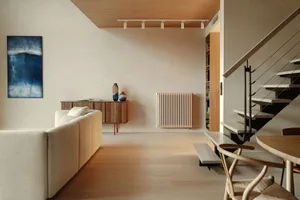 A modern residential interior featuring minimalist design, wood flooring, and contemporary furniture.
