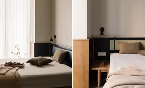A minimalist bedroom featuring a wooden bed frame with leather and textile bedding, minimalistic decor, and natural lighting