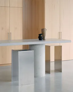 Minimalist desk with a concrete base in a modern interior setting.