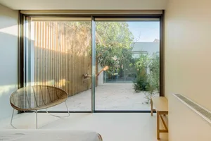 A minimalist living space featuring wooden walls and a large glass window