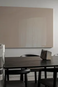 Modern dining table with wood finish and black chairs in a minimalist interior design setting.