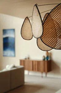 Teardrop-shaped woven lighting fixtures hanging from the ceiling in a contemporary living room setting.