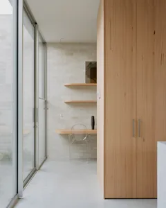 Home office with minimalist design, featuring a desk, shelves, and a wooden cabinet.