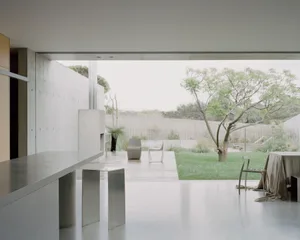 Clean, minimalist residential space featuring modern furniture and a seamless integration of indoor and outdoor elements.