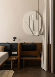 A modern bedroom with wooden furniture, a white relief sculpture on the wall, and a hanging lamp.