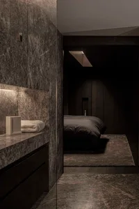 A modern bedroom featuring a marble wall and floor.
