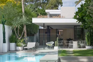 A modern residential patio featuring glass, metal, and concrete elements.