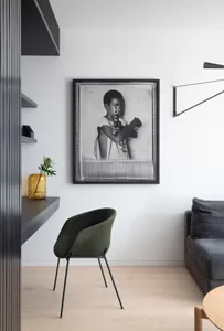 A modern living room featuring black furniture and wooden flooring.