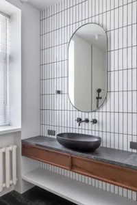 Modern bathroom featuring concrete tiles and a minimalist design with black fixtures and a floating vanity.