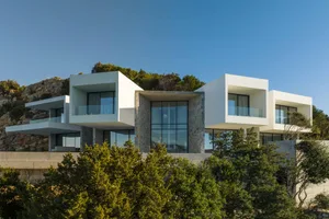 Modern house with concrete exterior and large glass windows.