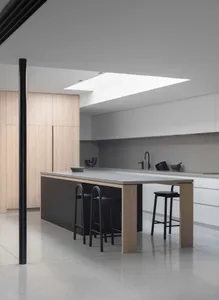Modern kitchen with a concrete island and white cabinets