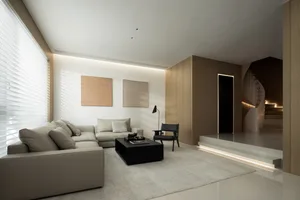 Modern living room with neutral tones, L-shaped sofa, coffee table, and minimalist decor.