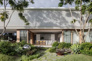 A modern residential exterior featuring a metal-clad facade with large windows and a landscaped garden.