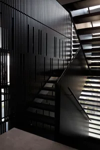 現代金屬室內空間，配有俐落黑色樓梯與牆面幾何圖案。