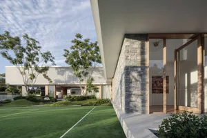 A modern residential exterior with stone, concrete, and glass materials