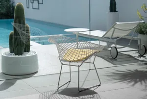 A modern metal chair with a yellow cushion placed on a terrace.