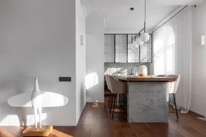 Modern kitchen with wood counter, glass cabinets, and concrete accents