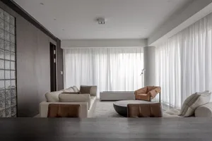 Modern living room featuring a neutral-toned color palette and a mix of leather and fabric furniture, creating a cozy and sop