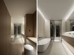 Modern, minimalist bathroom featuring a white bathtub and sleek, white furniture against light-colored walls and floors.