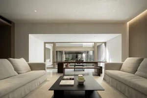 A modern living room with neutral-colored sofas and a minimalist coffee table.