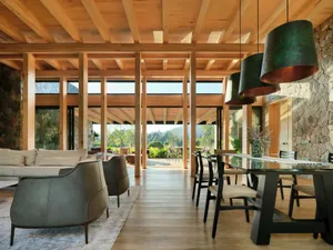 Modern interior with wooden beams, sofas, tables, and chairs.