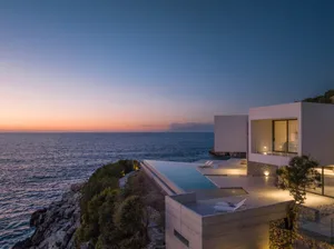 A modern minimalist sea-view villa featuring concrete and glass materials.