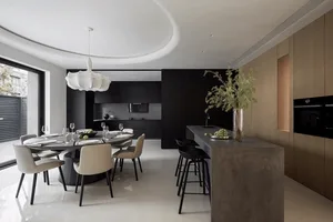 A modern kitchen with white concrete countertops and black cabinetry.