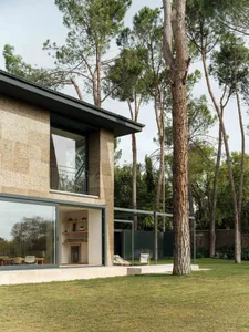Contemporary residential exterior featuring large windows and stone cladding.