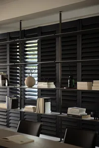 A modern, industrial-style library with metal shelving units featuring black shutters and books arranged neatly.