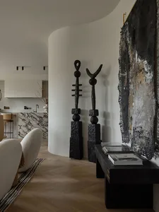 Modern living room interior with black sculptural art pieces, a marble countertop, and minimalist decor