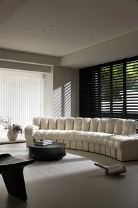 Modern white fabric sofa in a living room with sunlight streaming through the window.