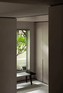 A minimalist bedroom featuring glass cabinets, minimalistic design, and a modern aesthetic.