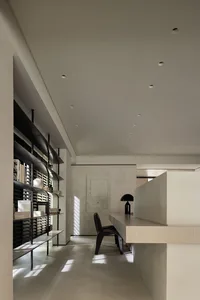 A minimalist home office featuring a concrete cabinet and a sleek, contemporary workspace.