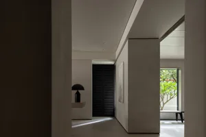 Modern minimalist residential interior with concrete walls, black shutters, and a sleek design.