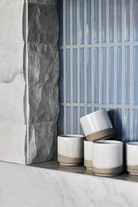 White ceramic cups with a brown base and blue ceramic tiles on a wall