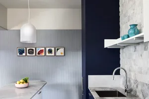 Modern kitchen with marble countertops and minimalist design elements.