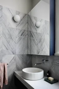 A modern minimalist bathroom with marble walls.