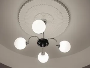 A minimalist ceiling light fixture with metal elements against a plain background.