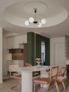 A modern kitchen and dining area with a marble table and concrete elements.