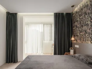 A modern bedroom featuring velvet curtains and floral wallpaper