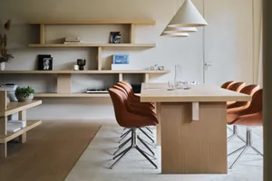 A modern conference room with wooden furniture, shelves, and chairs.