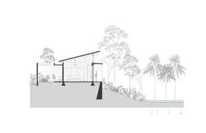 A minimalist residential building with glass walls and concrete structure, set against a natural landscape.