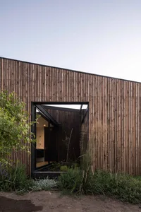 Modern exterior wooden siding and black-framed triangular window