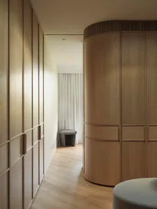Modern, minimalist wardrobe interior with wooden doors and curved panels.