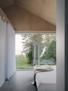 Bedroom with minimalist design, large window, and natural view.