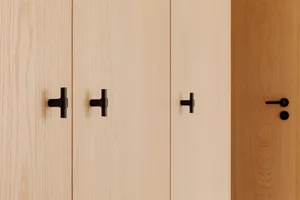 Black minimalist drawer knobs on light-colored wooden doors