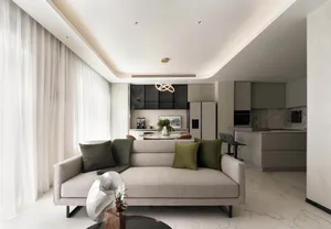 Modern minimalist living room with gray couch, green pillows, and a contemporary chandelier.