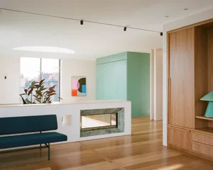 Modern minimalist living room featuring a sleek white fireplace, minimalist wood furniture, and a large window with natural l