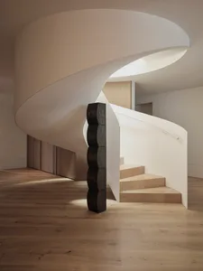 Modern interior design featuring a wooden staircase with sleek, minimalist lines.