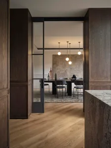 Dining room with minimalist decor, featuring a black dining table with black chairs and pendant lights above.